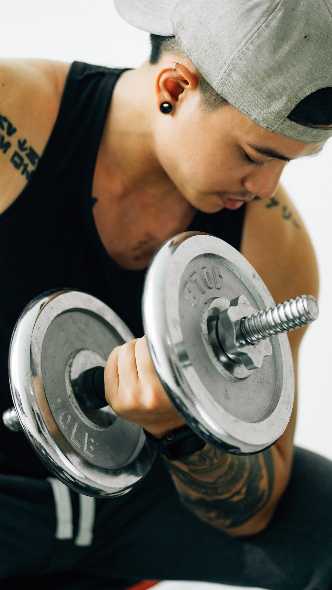 A portrait of a trans man lifting weights.